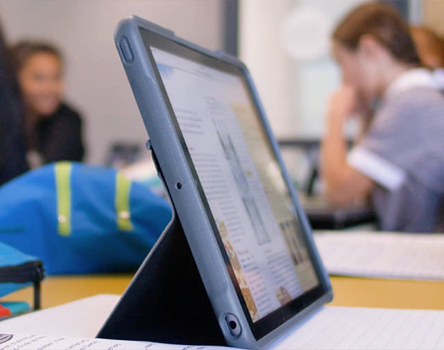 Open laptop, side view, children in background